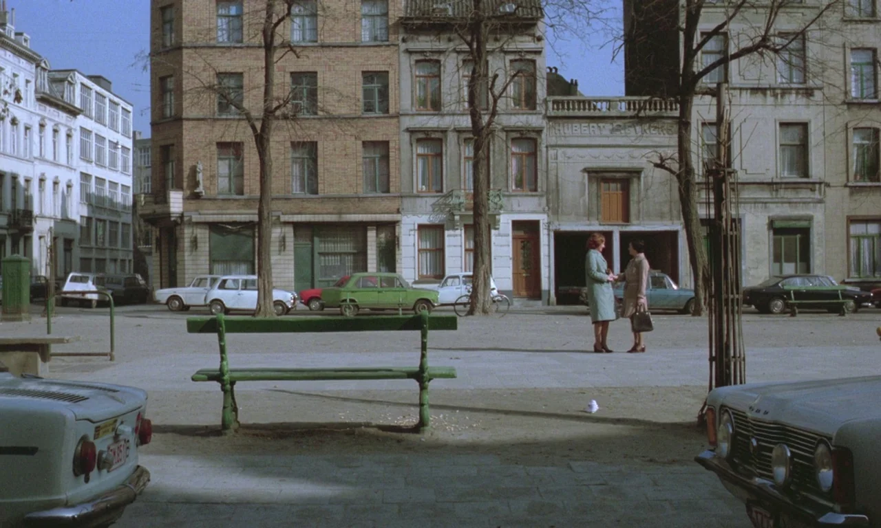 Jeanne Dielman, 23, quai du commerce, 1080 Bruxelles (1975) movie still: wide — An open paved city square is flanked by multi-story brick apartment…
