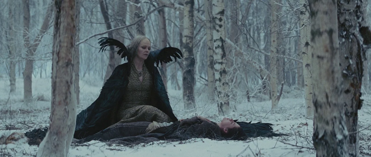 Snow White and The Huntsman (2012) movie still: medium — A snowy, barren birch forest provides a stark backdrop for two women. One woman kneels on…