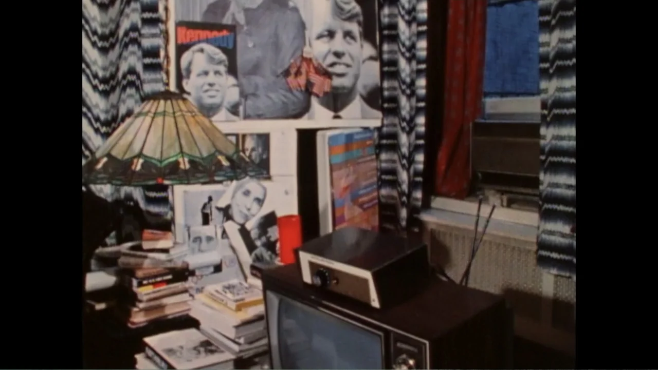 Dear Ms.: A Revolution in Print (2025) movie still: medium — A cluttered study desk with stacks of books and political posters on the wall. A…