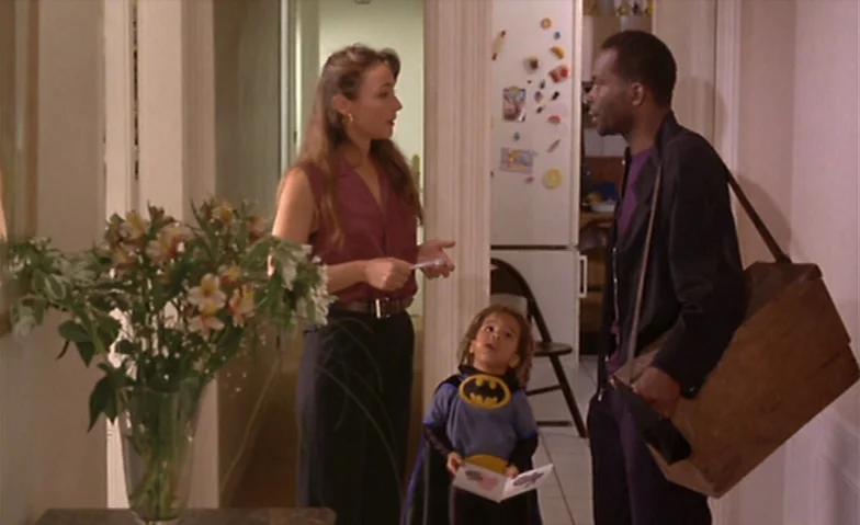 I Can’t Sleep (1994) movie still: medium — A residential hallway connects to a kitchen area where magnets are attached to a refrigerator. A woman…