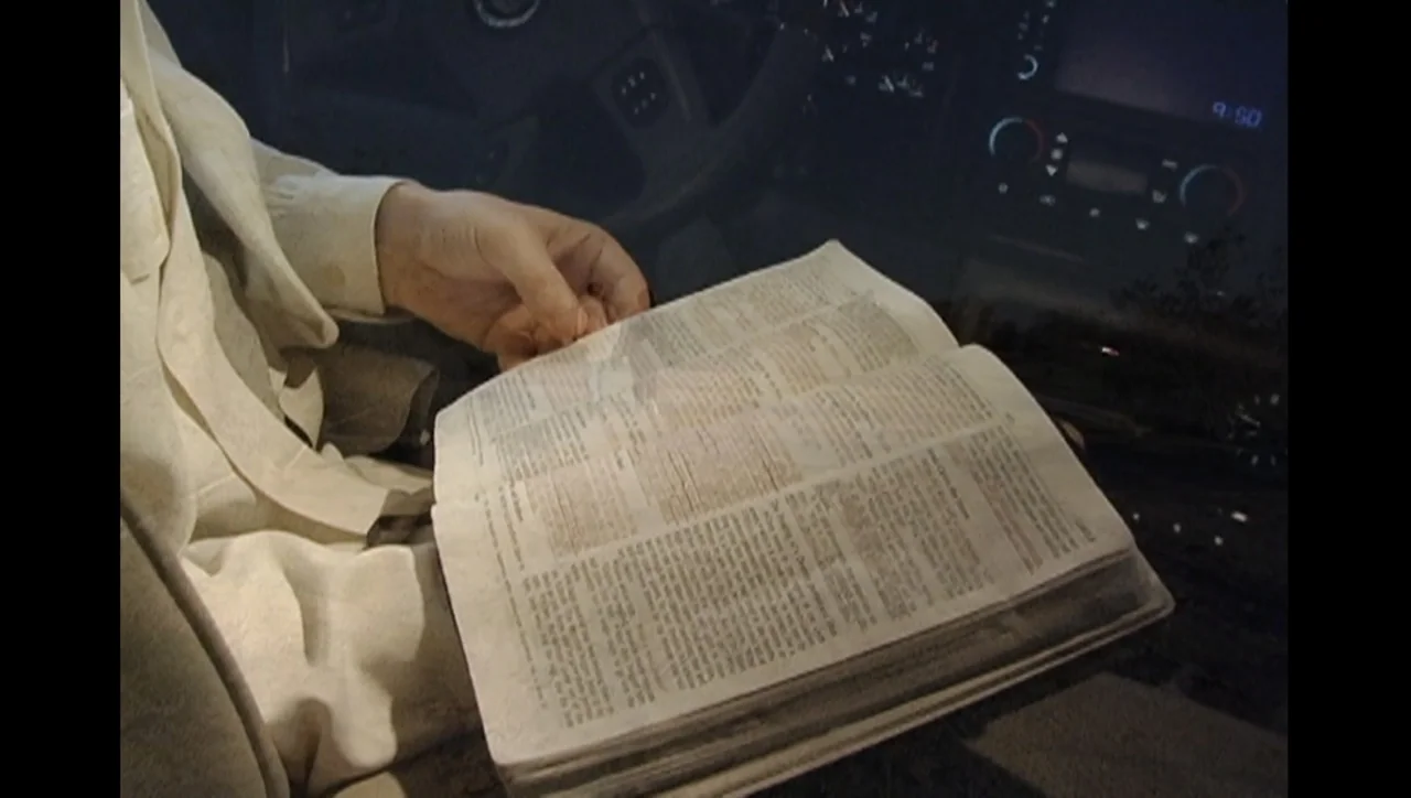 The Trials of Ted Haggard (2009) movie still: medium — The interior of a vehicle cabin at night with a digital dashboard display visible. A person…