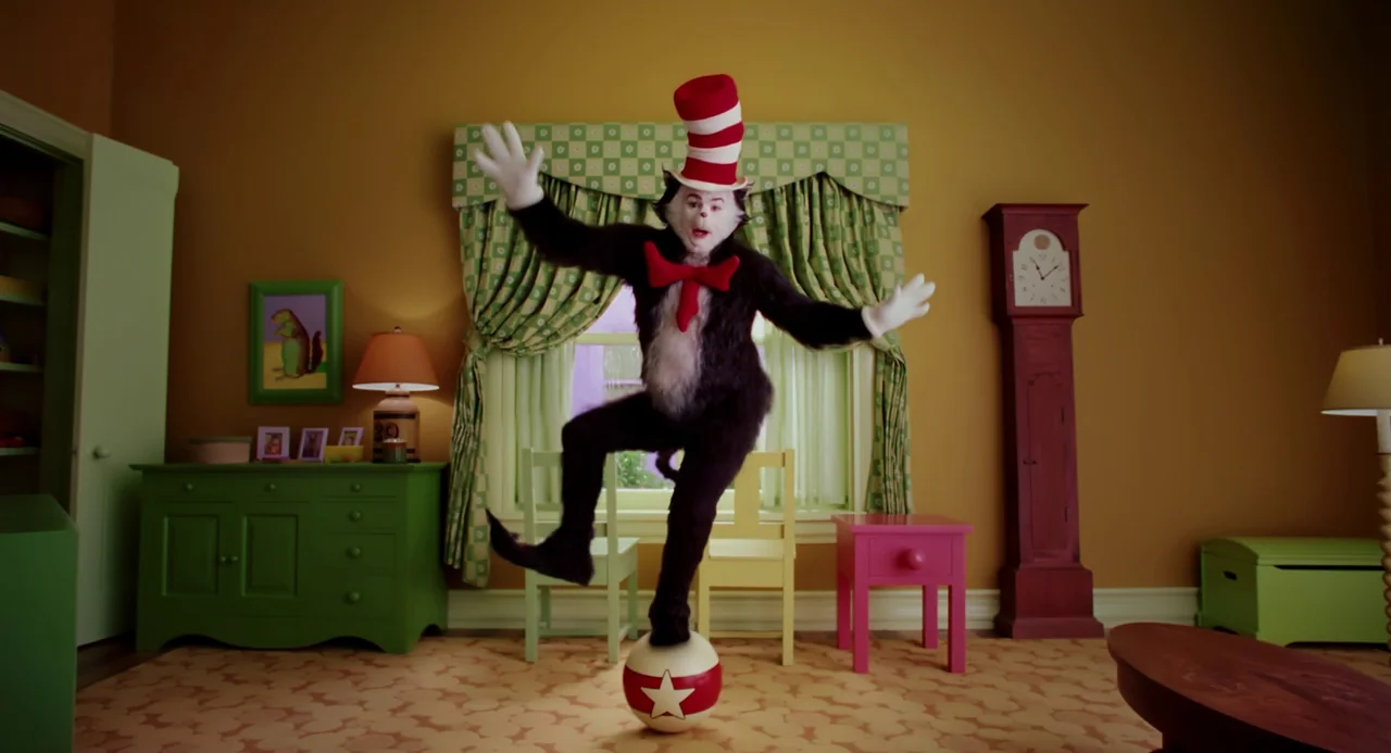 The Cat In The Hat (2003) movie still: fullbody — A living room features bright green furniture and mustard yellow walls with patterned curtains. An…