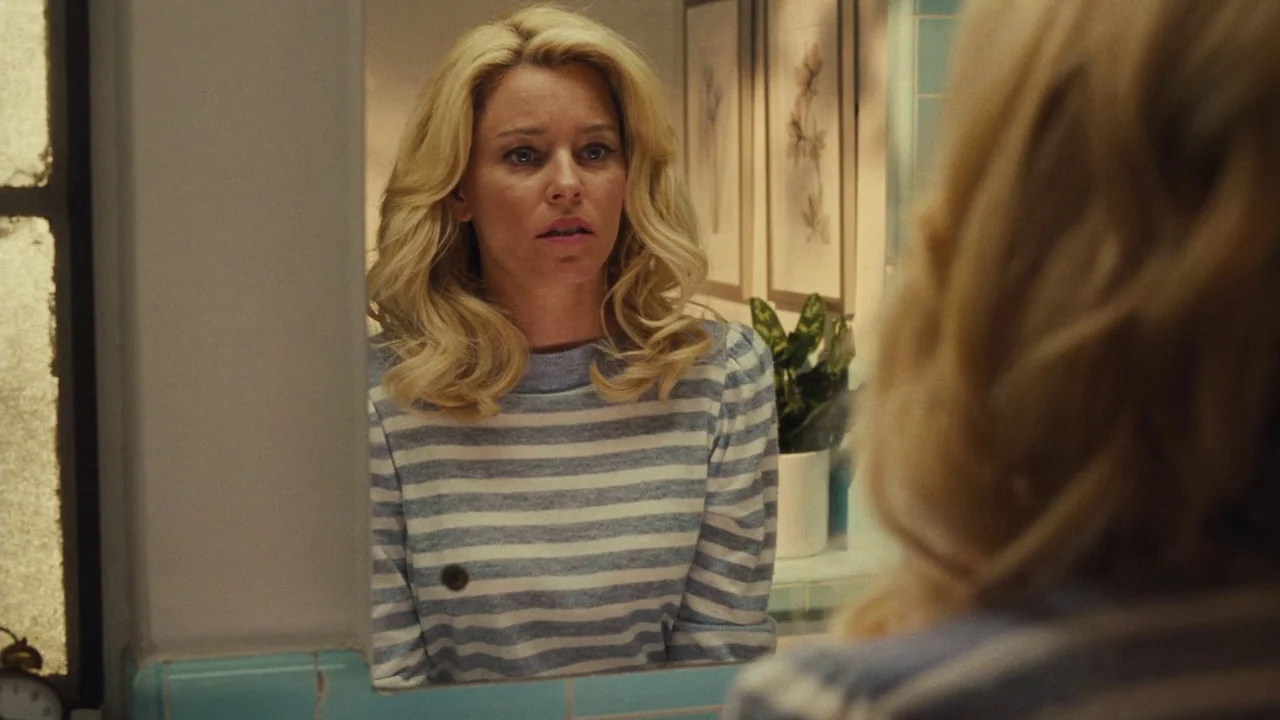 Love & Mercy (2014) movie still: medium — A well-lit residential bathroom features teal tiling and framed botanical art on the wall. A blonde woman…
