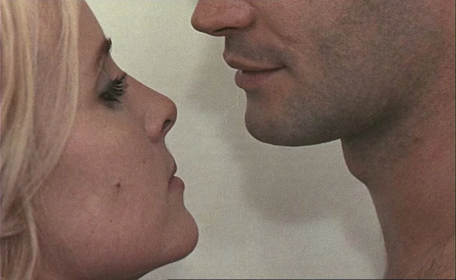 Le Bonheur (Happiness) (1965) movie still: closeup — The frame shows the side profiles of a man and a woman indoors. They are positioned…