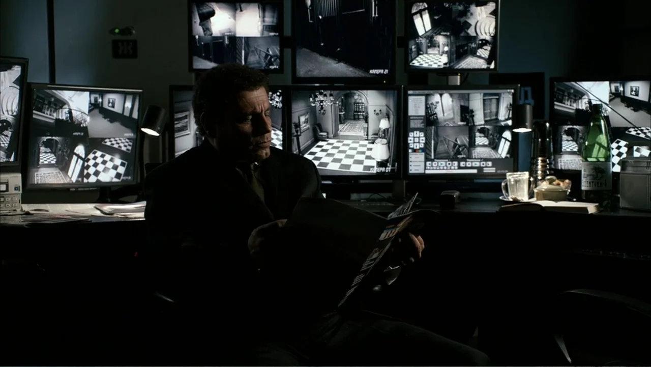 Get Smart (2008) movie still: medium — A dark security room contains multiple monitors displaying black and white surveillance footage. A…