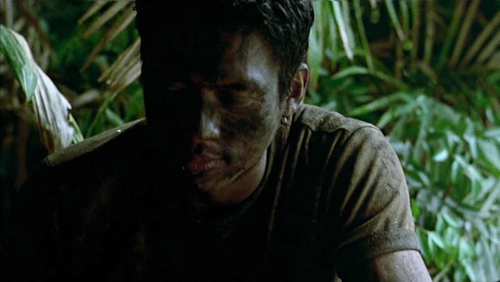 Tropical Malady (2004) movie still: medium — A dense green jungle background with foliage blurred by a shallow depth of field. A man with a…