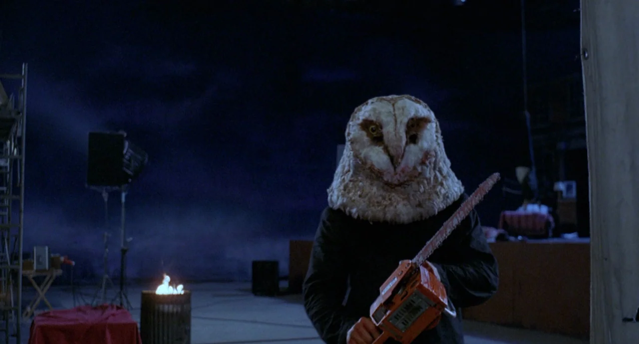 StageFright (1987) movie still: medium — A dark, empty soundstage interior with visible production equipment in the background shadows. A figure…