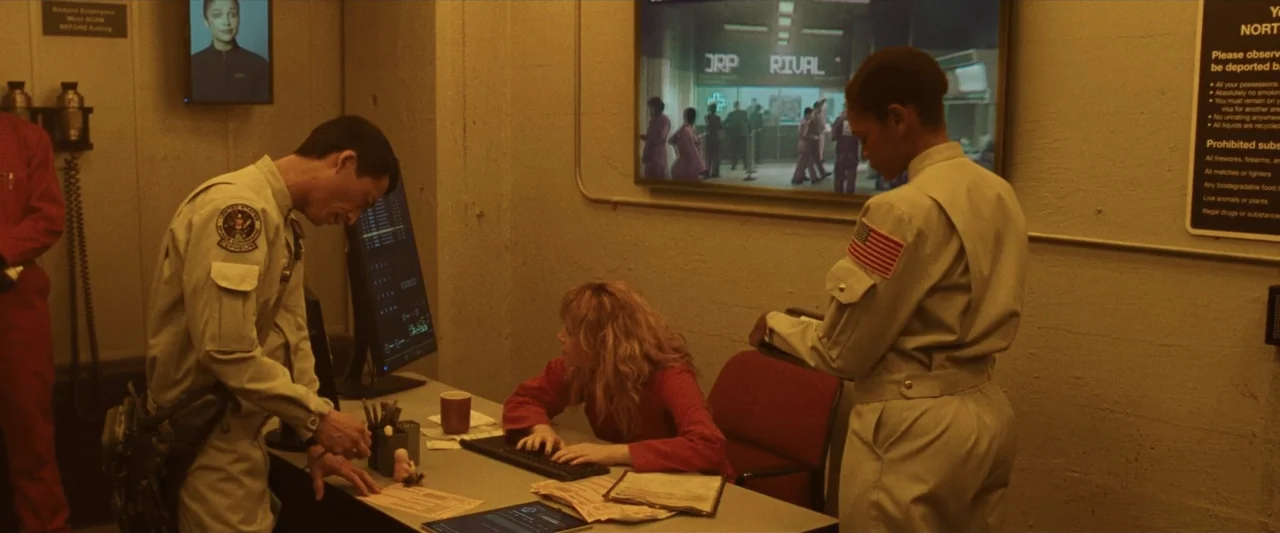 Ad Astra (2019) movie still: medium — A stark security station features concrete walls with posted rules and digital monitors. Two uniformed guards…