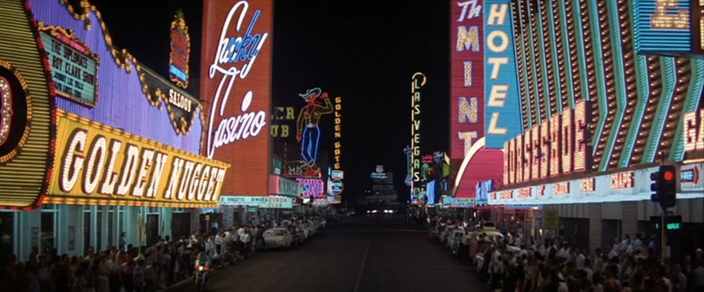 Viva Las Vegas (1964) movie still: establishing — A bustling street at night in downtown Las Vegas lined with brightly lit casinos. Rows of…