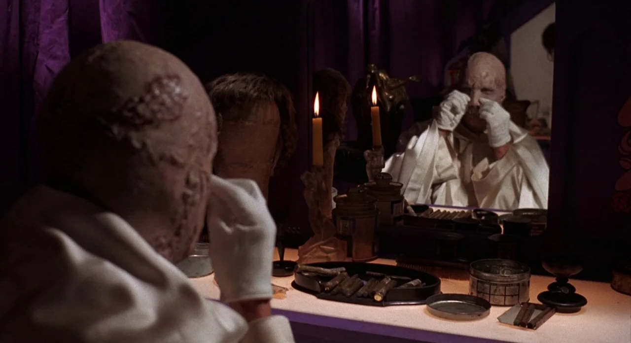 The Abominible Dr. Phibes (1972) movie still: medium — A dimly lit dressing room features purple curtains, a vanity table, and candle lighting. A…