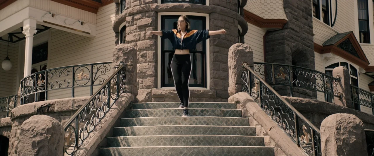 Equation of Love and Tone Deafness (2015) movie still: fullbody — A historic stone house with an ornate iron railing leading to the front door. A…