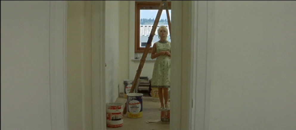 Contempt (Le Mépris) (1963) movie still: fullbody — A room undergoing renovation with white walls and scattered paint cans on the floor. A woman…