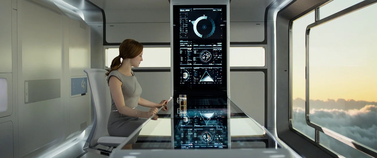 Oblivion (2013) movie still: medium — A sterile, minimalist room features high-tech white panels and a large transparent digital desk. A woman sits…