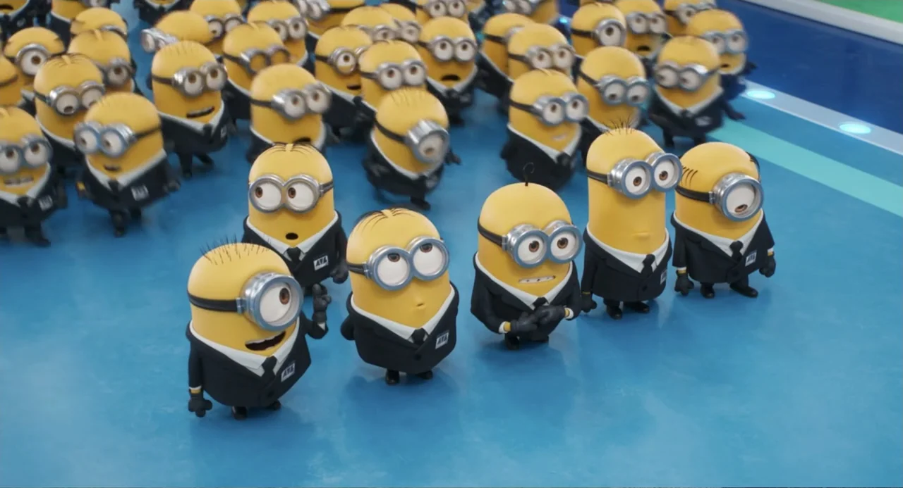 Despicable Me 4 (2024) movie still: fullbody — A crowd of yellow pill-shaped creatures stands on a smooth blue floor indoors. Each individual wears…