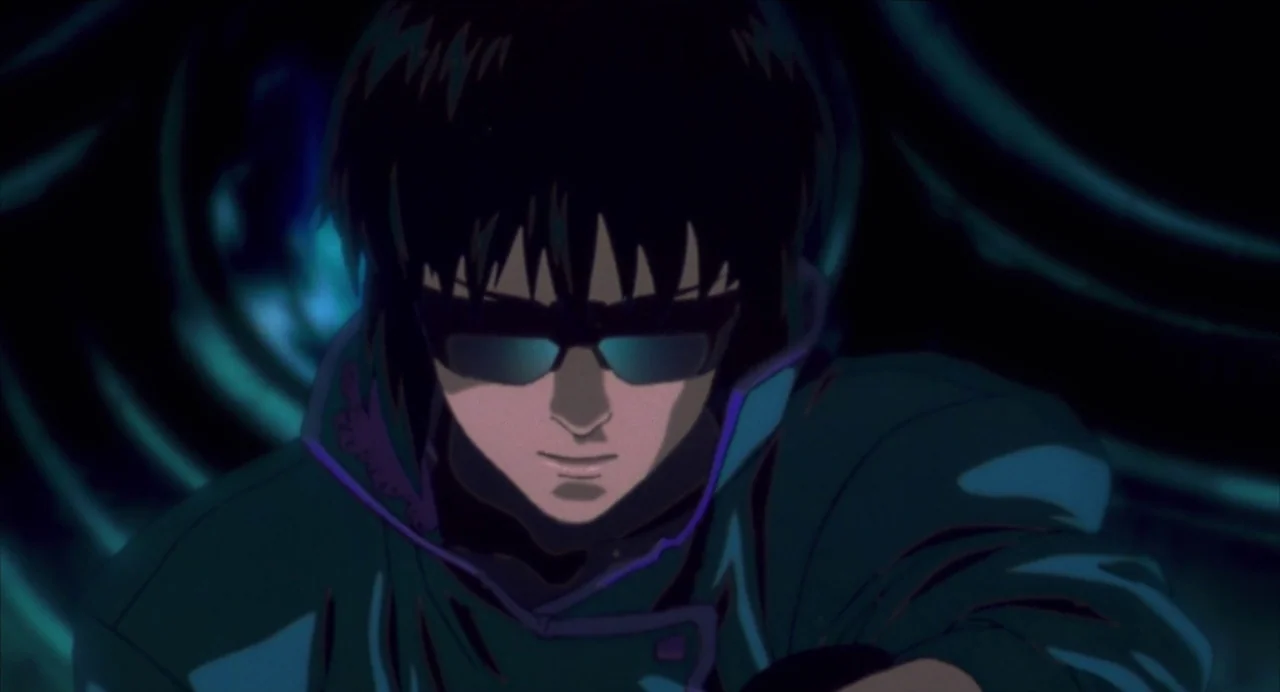 Ghost in the Shell (1995) movie still: closeup — A dark space with abstract blue swirling lines in the background. A man with short black hair and…