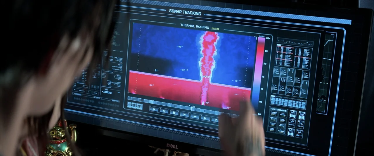 The Meg (2018) movie still: medium — A dark workspace is dominated by a large computer monitor displaying sonar tracking data. A person with a…