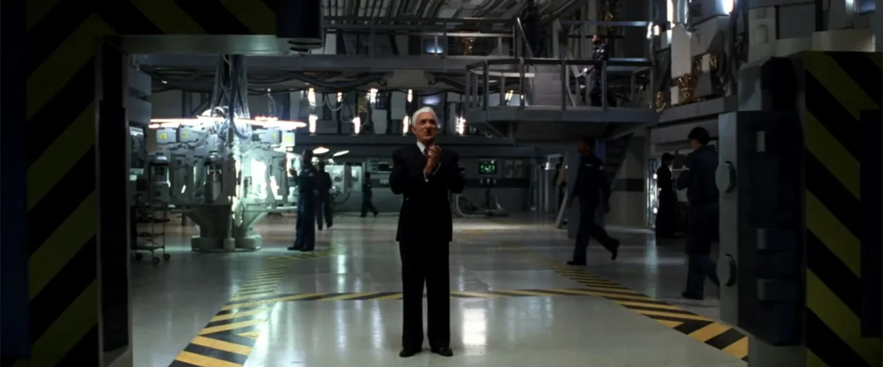 A Sound of Thunder (2005) movie still: fullbody — An industrial laboratory features a large metallic machinery structure and elevated metal…