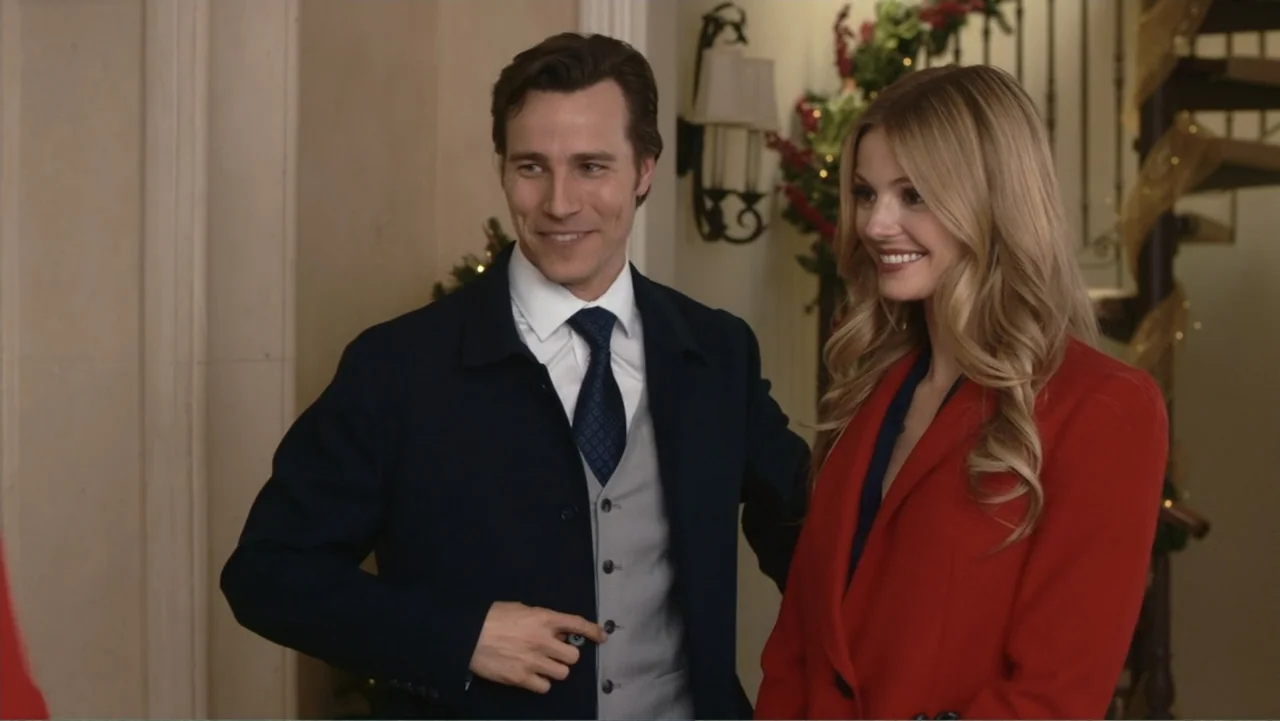 Driving Madeleine (2022) movie still: medium — A well-lit residential foyer contains a spiral staircase and festive holiday decorations. A man in a…