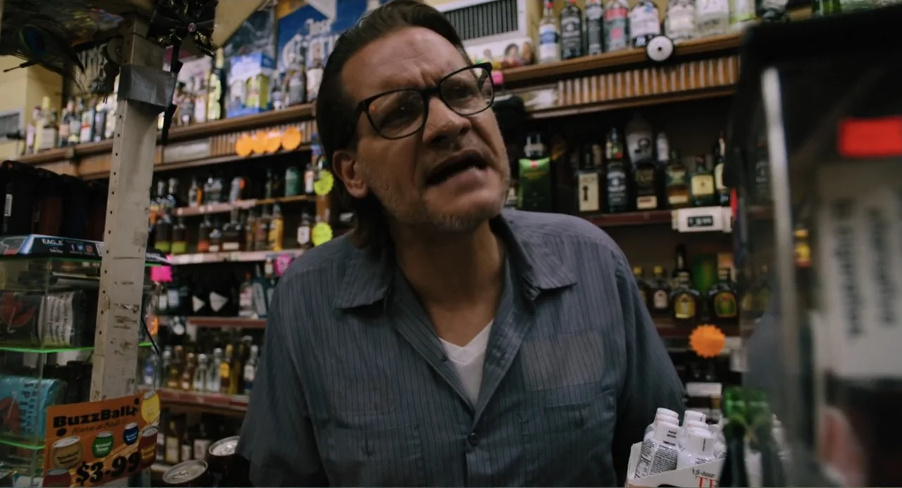 Mona Lisa and the Blood Moon (2022) movie still: medium — A cluttered liquor store interior features wooden shelves stocked with various glass…