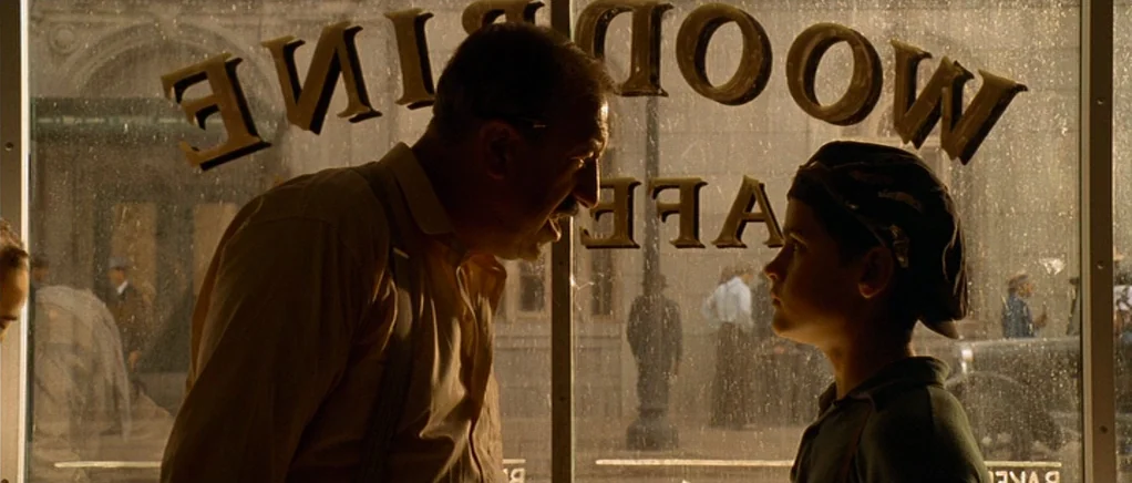 King of the Hill (1993) movie still: medium — A man and a boy stand on opposite sides of a glass window displaying lettering. The exterior street…