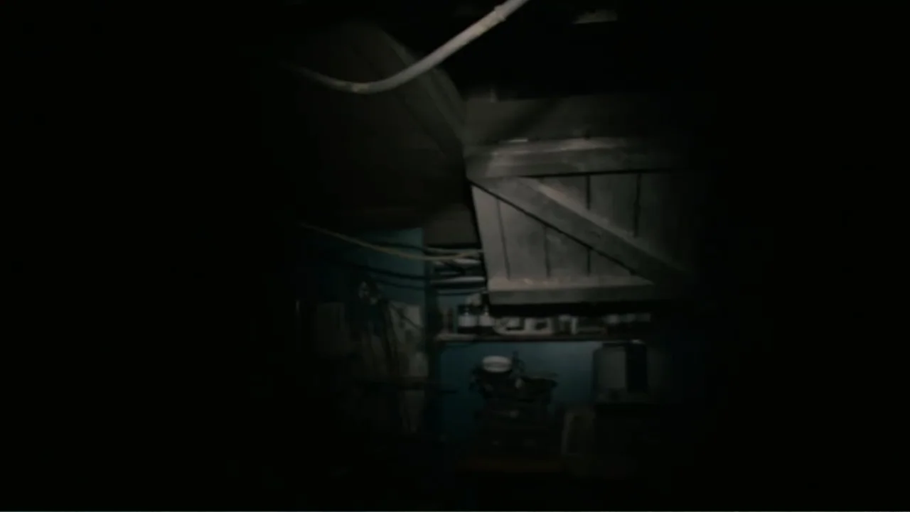 Quarantine (2008) movie still: establishing — A dark, cluttered basement interior is partially illuminated by a single concentrated light beam.…