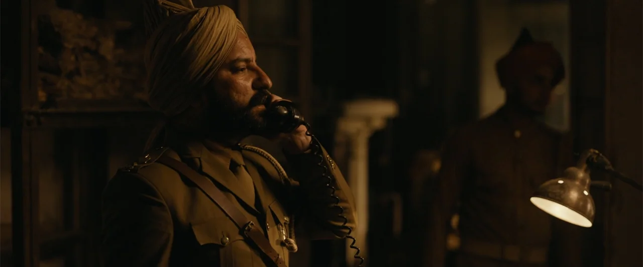 Sardar Udham (2021) movie still: medium — A dimly lit room with an officer in military uniform near metal shelving. The soldier stands in profile…