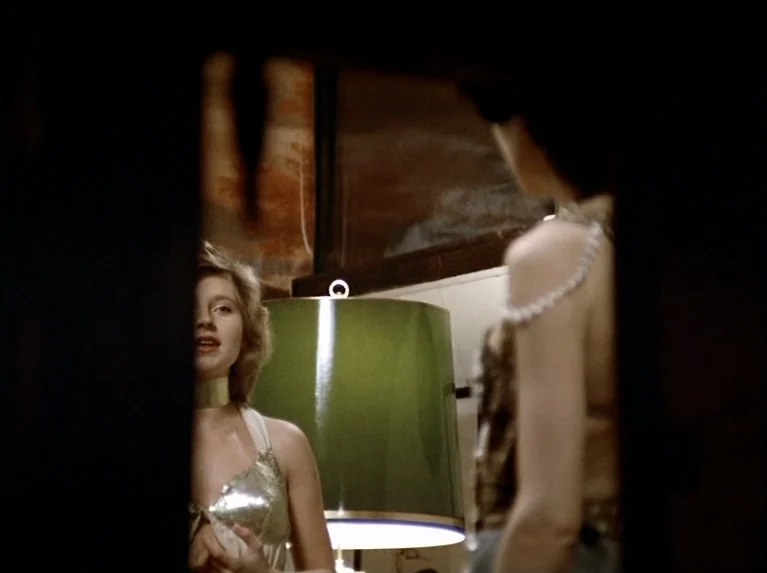 The Bitter Tears Of Petra Von Kant (1972) movie still: medium — An interior space framed by dark foreground elements with a central lamp between…