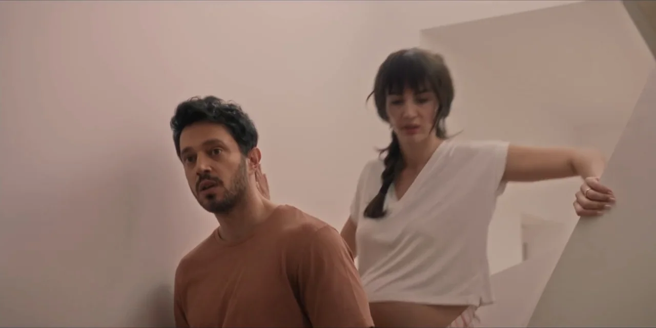 Kill Me If You Dare (2019) movie still: medium — A minimalist white staircase interior with clean walls and angular architectural lines. A man and a…