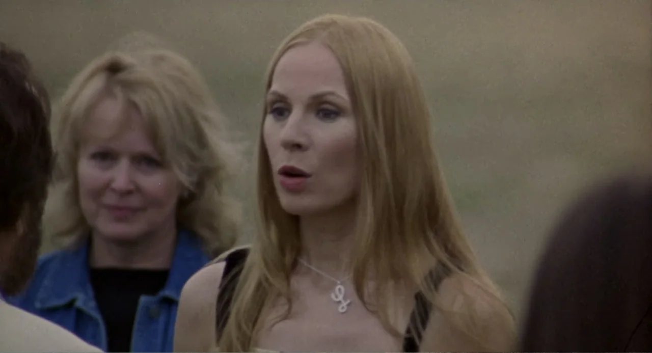Forty Shades of Blue (2005) movie still: medium — An open outdoor area provides a neutral background for the two women standing nearby. The primary…