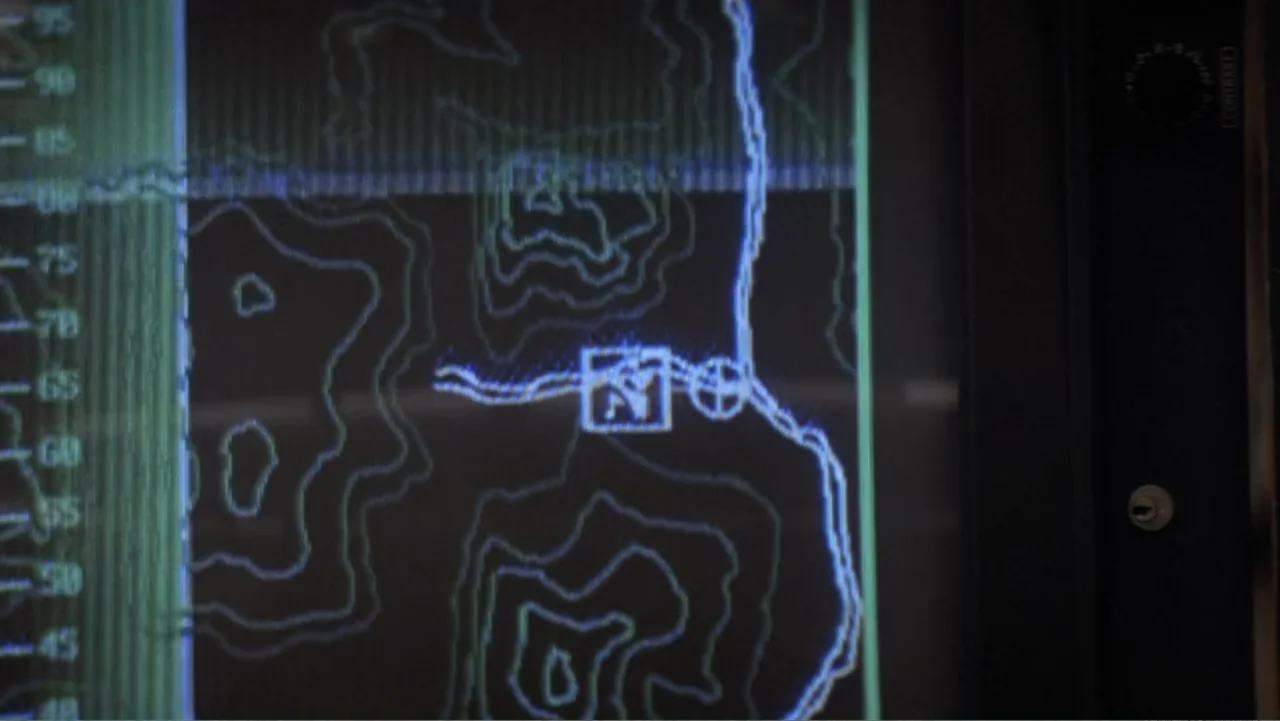 Capsized: Blood in the Water (2019) movie still: closeup — A close-up of a dark digital display monitor showing a bright topographic navigation map.…