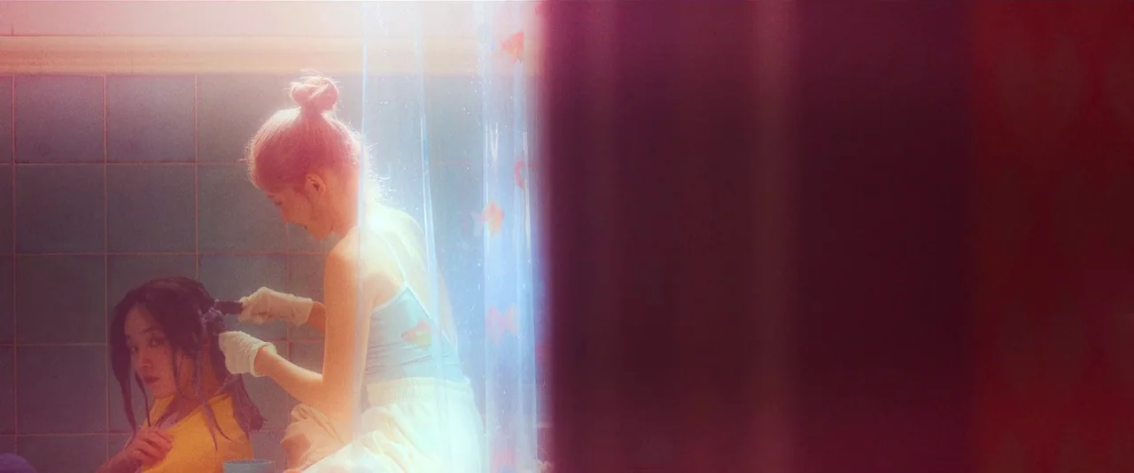 Ballerina (2023) movie still: medium — A tiled bathroom features a translucent plastic curtain decorated with small goldfish silhouettes. One woman…