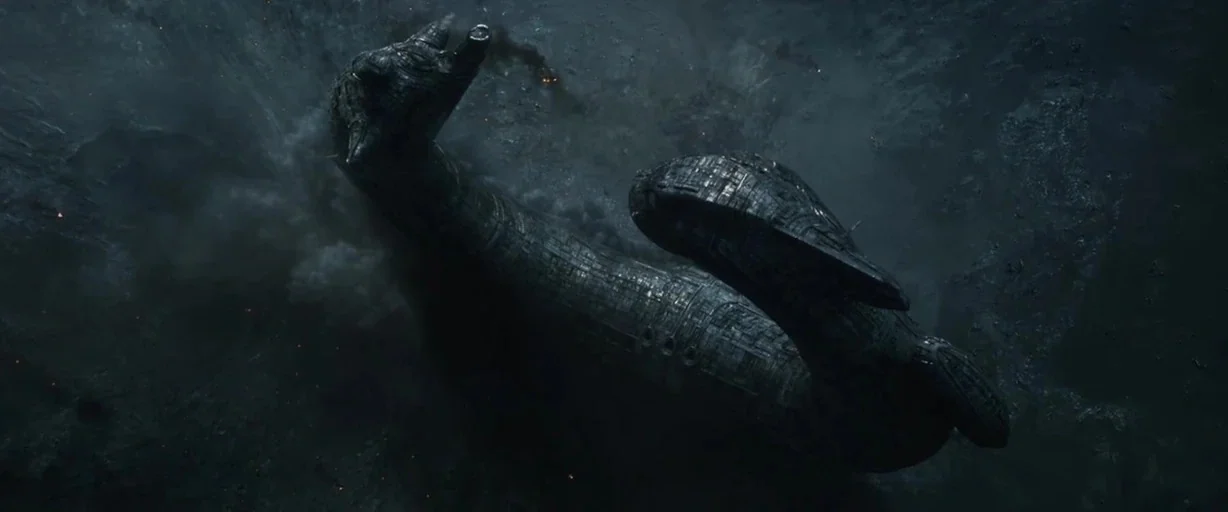 Prometheus (2012) movie still: wide — A dark, metallic, organic-shaped spacecraft floats through a debris-filled expanse of deep space. Smoke curls…