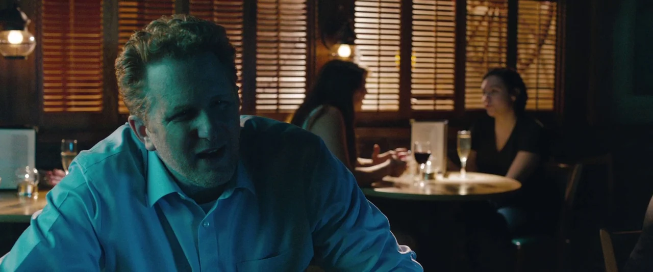 Kiss of the Damned (2012) movie still: medium — A dimly lit restaurant interior features wooden shutters behind diners at tables. A middle-aged man…