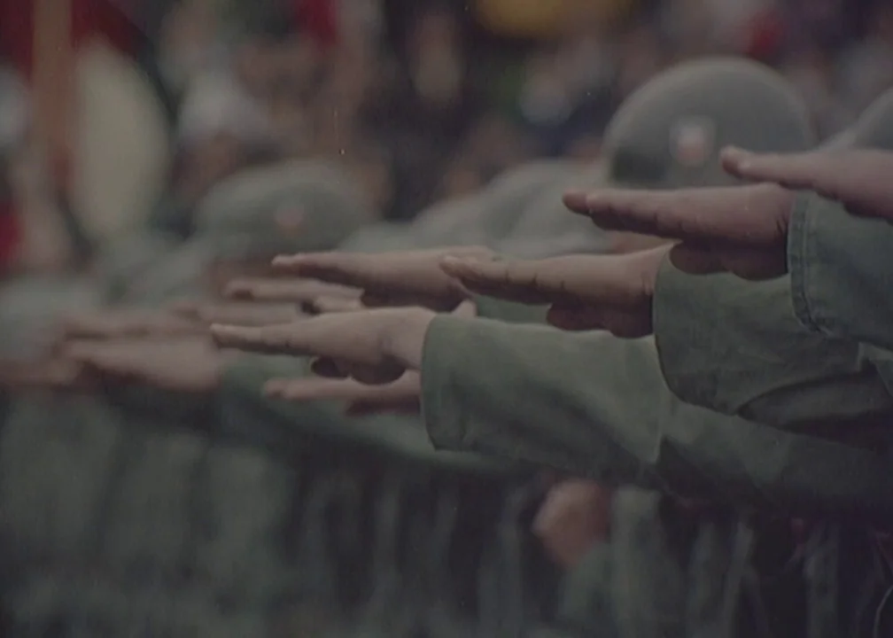 No (2012) movie still: medium — A group of soldiers stand in formation during a public event. They perform a collective gesture with their arms…