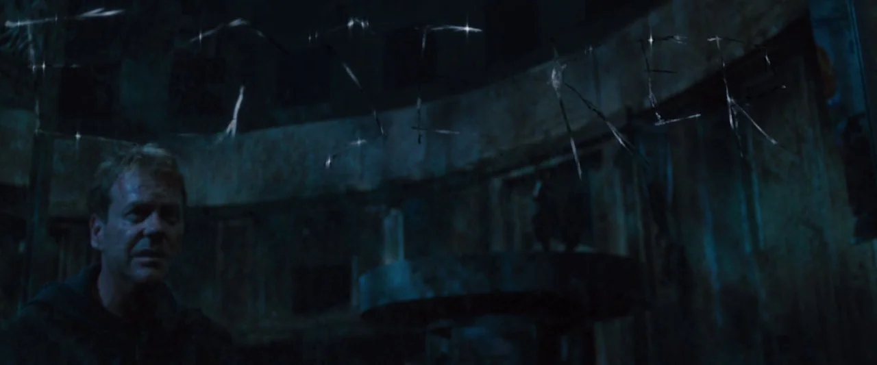 Mirrors (2008) movie still: medium — A dimly lit, decaying structure with dark, grime-covered walls. A man stares forward from behind a cracked and…
