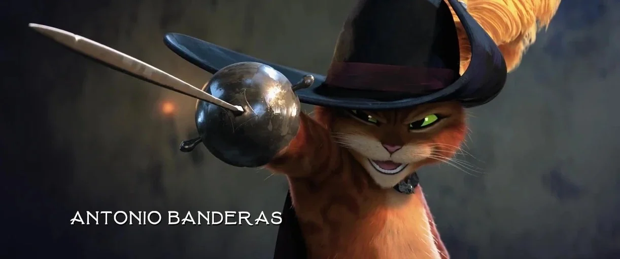 Puss in Boots: The Last Wish (2022) movie still: closeup — A dark, dimly lit environment provides a backdrop for a stylized orange cat. The cat…