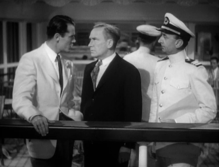 The Lady Eve (1941) movie still: medium — A group of men stand on the deck of a ship during the day. Three men in suits and a uniform stand together…