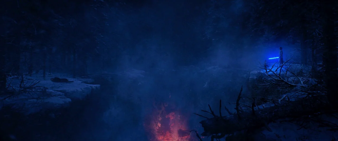 Star Wars: The Force Awakens (2015) movie still: wide — A snowy, dark coniferous forest surrounds a deep chasm filled with glowing magma. A lone…