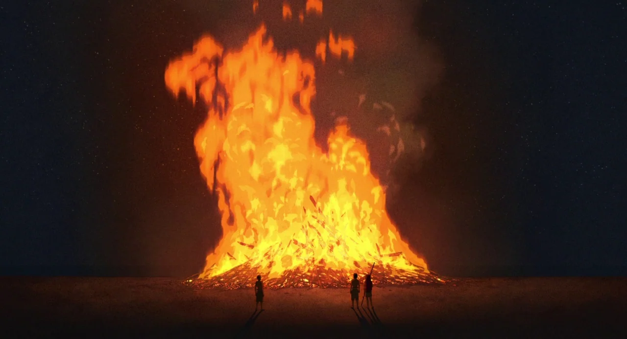 The Red Turtle (2016) movie still: wide — A large bonfire burns brightly in a dark, open field under a night sky. Three small figures stand at the…