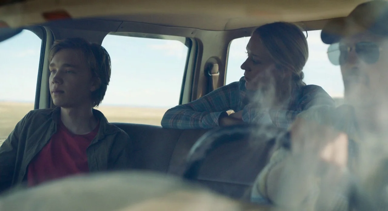 Lean on Pete (2017) movie still: medium — Three people sit inside a moving vehicle traveling through an open rural landscape. They look toward the…