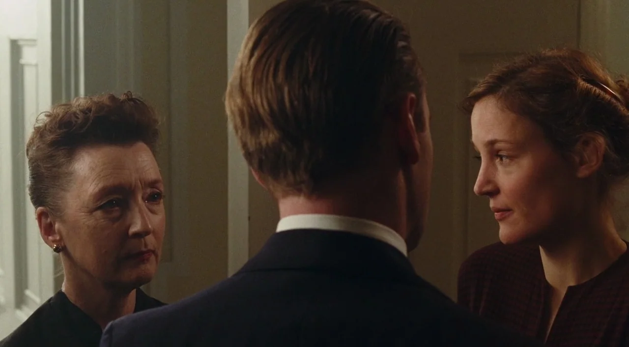 Phantom Thread (2017) movie still: medium — A narrow interior hallway features light-colored walls and a classic architectural door frame. Three…