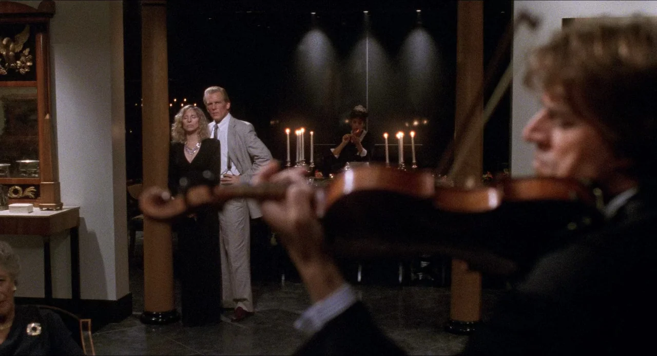 The Prince of Tides (1991) movie still: medium — A dimly lit room features a dining table adorned with several tall burning candles. A musician…