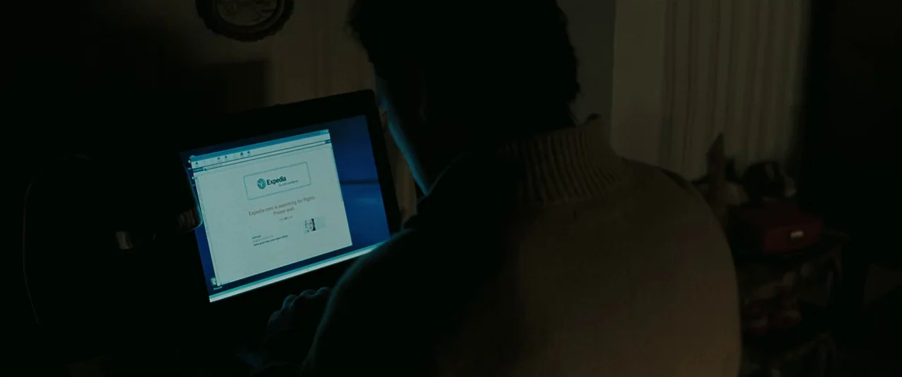 Two Lovers (2008) movie still: medium — A dimly lit room holds a person sitting before a glowing laptop screen. The subject uses a browser to search…