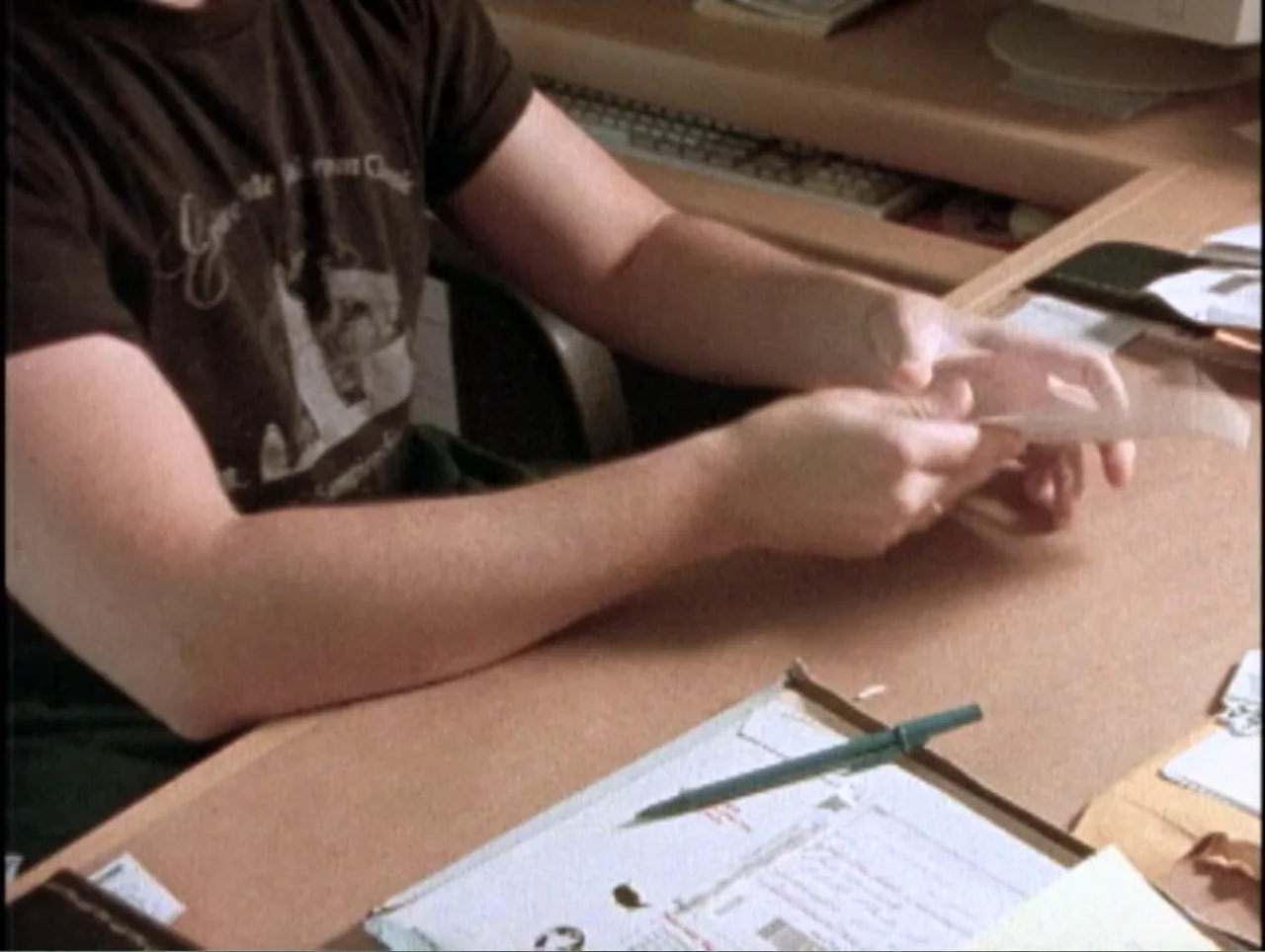 America Undercover: Life Afterlife (2000) movie still: medium — A light-colored wooden desk is covered with assorted office documents and a…