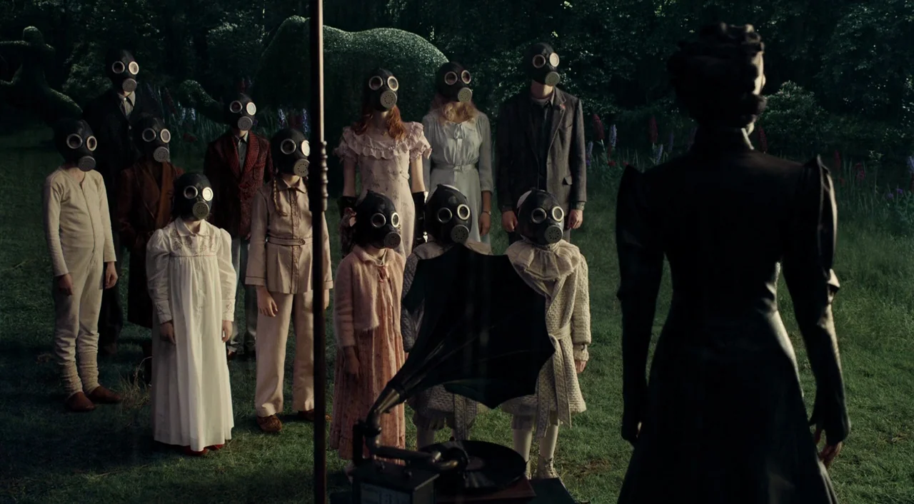 Miss Peregrine’s Home for Peculiar Children (2016) movie still: wide — A group of people wearing gas masks stand on a grassy lawn. They gather in a…