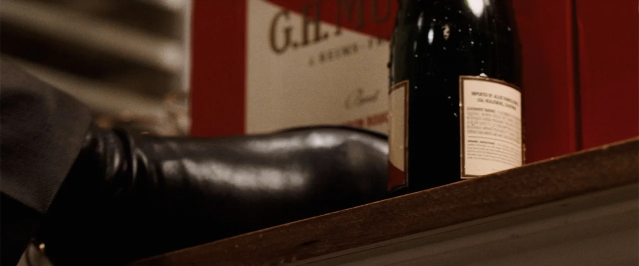 Ghosts of Girlfriends Past (2009) movie still: closeup — A close view of a shelf containing a bottle of G.H. Mumm champagne. A black leather shoe…