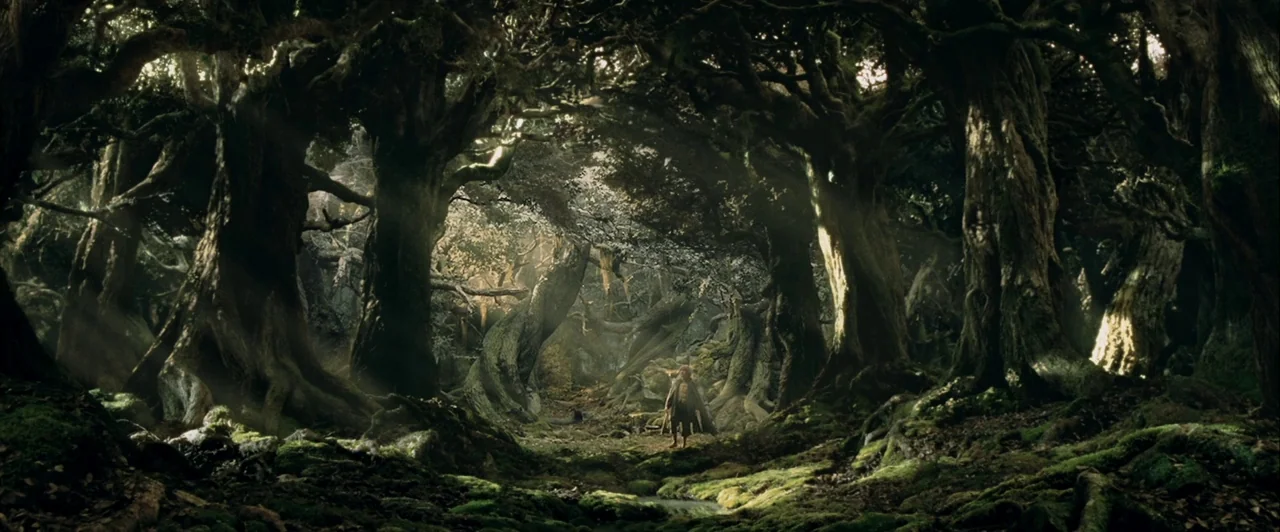 The Lord of The Rings: The Two Towers (2002) movie still: wide — A dense, ancient forest features massive gnarled trees covered in moss and twisted…