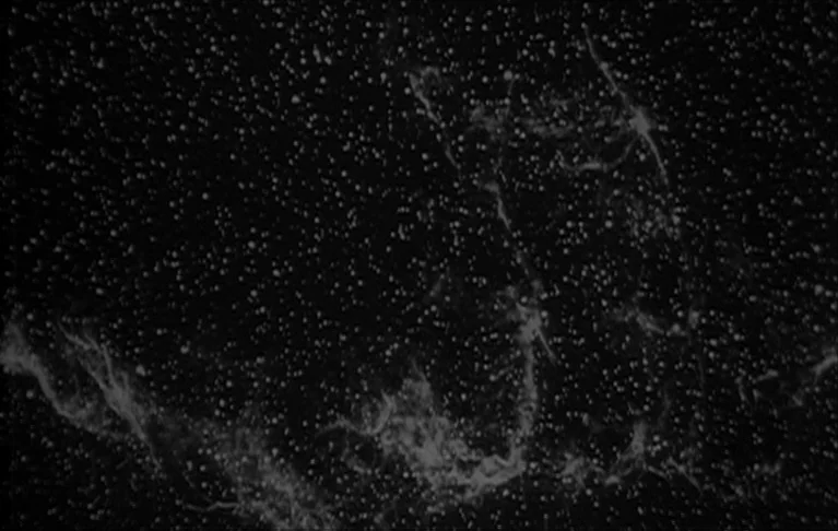 Le Signe du Lion (1962) movie still: establishing — A dense starfield stretches across the frame with wisps of nebular gas clouds. The scene…
