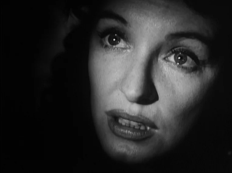 Oliver Twist (1948) movie still: closeup — A close-up shot focuses on a woman's face against a black, undefined background. She gazes upwards with…
