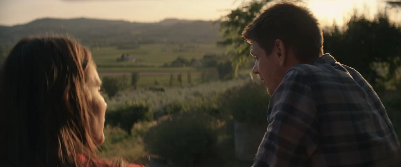 The Only One (2021) movie still: medium — An outdoor hillside landscape during sunset with blurred trees and fields in the background. A man and a…